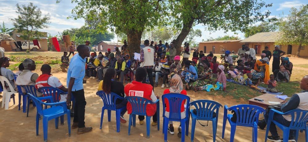 Community dialogue session with beneficiaries seated in a circle